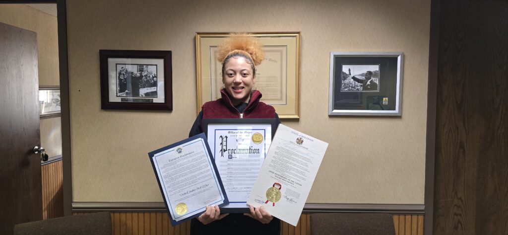 A photo of Milwaukee steward Kaela Kincaid holding the signed proclamations