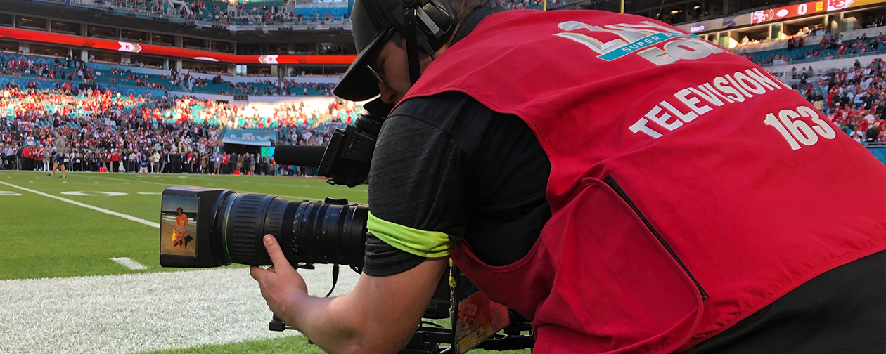 New York Local 1212 member Kyle Hagen gets low to the ground to work a camera while preparing to shoot the action during Super Bowl 54. Hagen was one of more than 400 IBEW members working the game for Fox Sports.