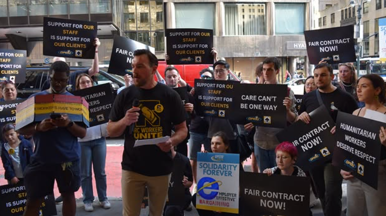 IRC workers at a rally hold signs calling for a fair contract.