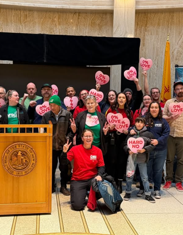 State workers rallying for their raise with a Valentine’s Day themed action featuring pink heart signs that read, “Hard no” and “0% love.”
