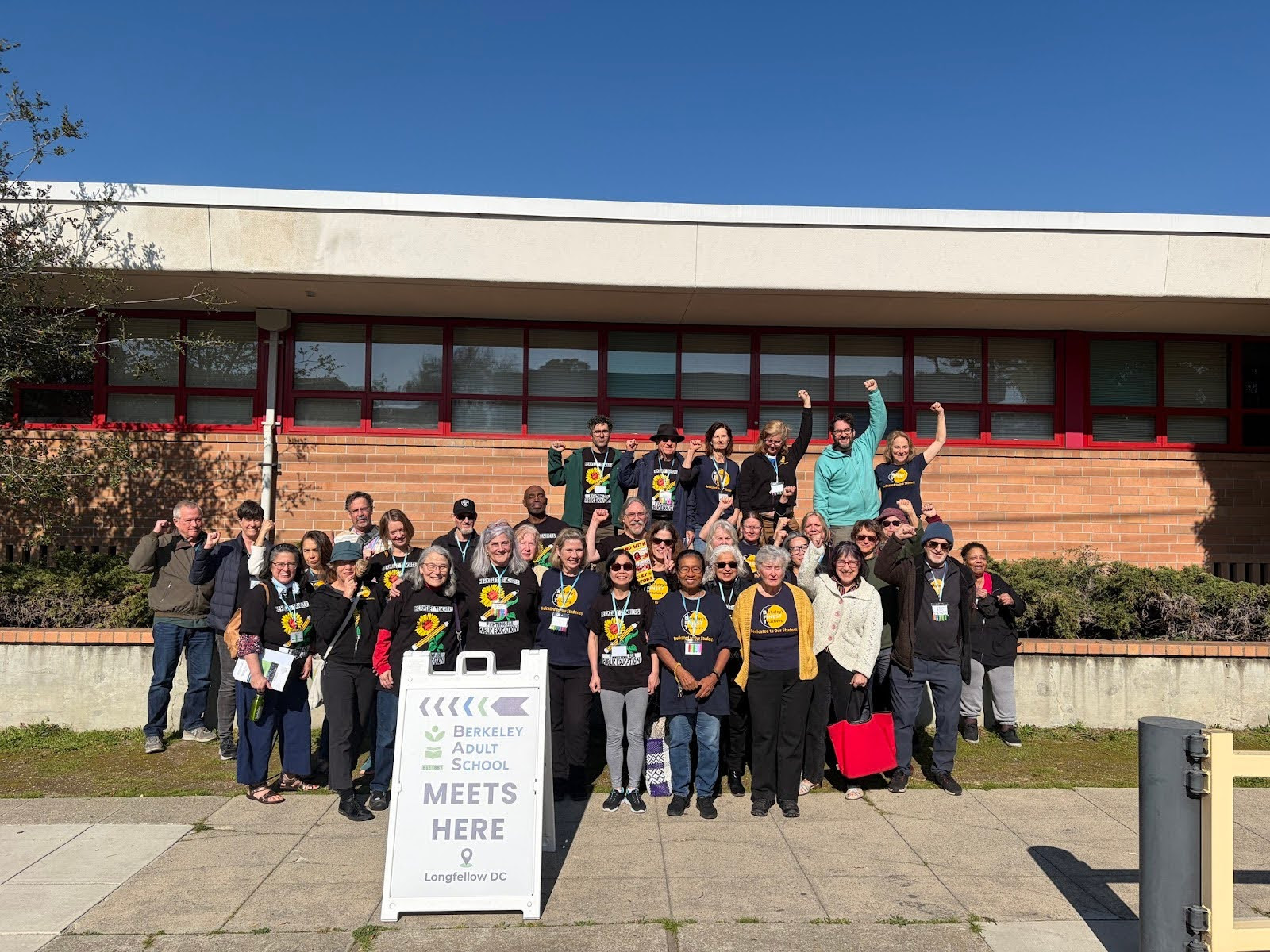 Berkeley teachers pose for a picture with fists raised.