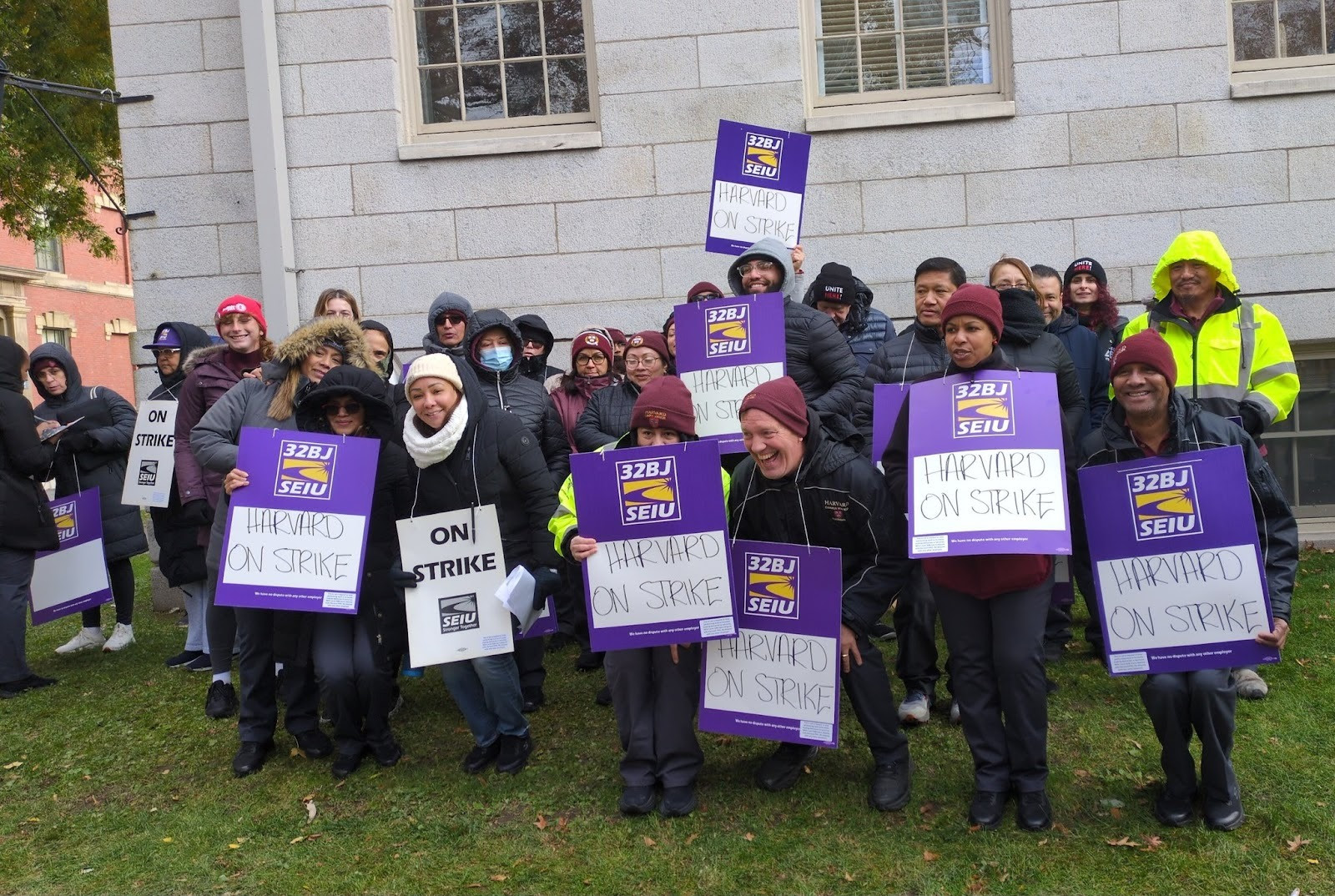 SEIU members pose for a group picture with signs that read, “Harvard on strike.”