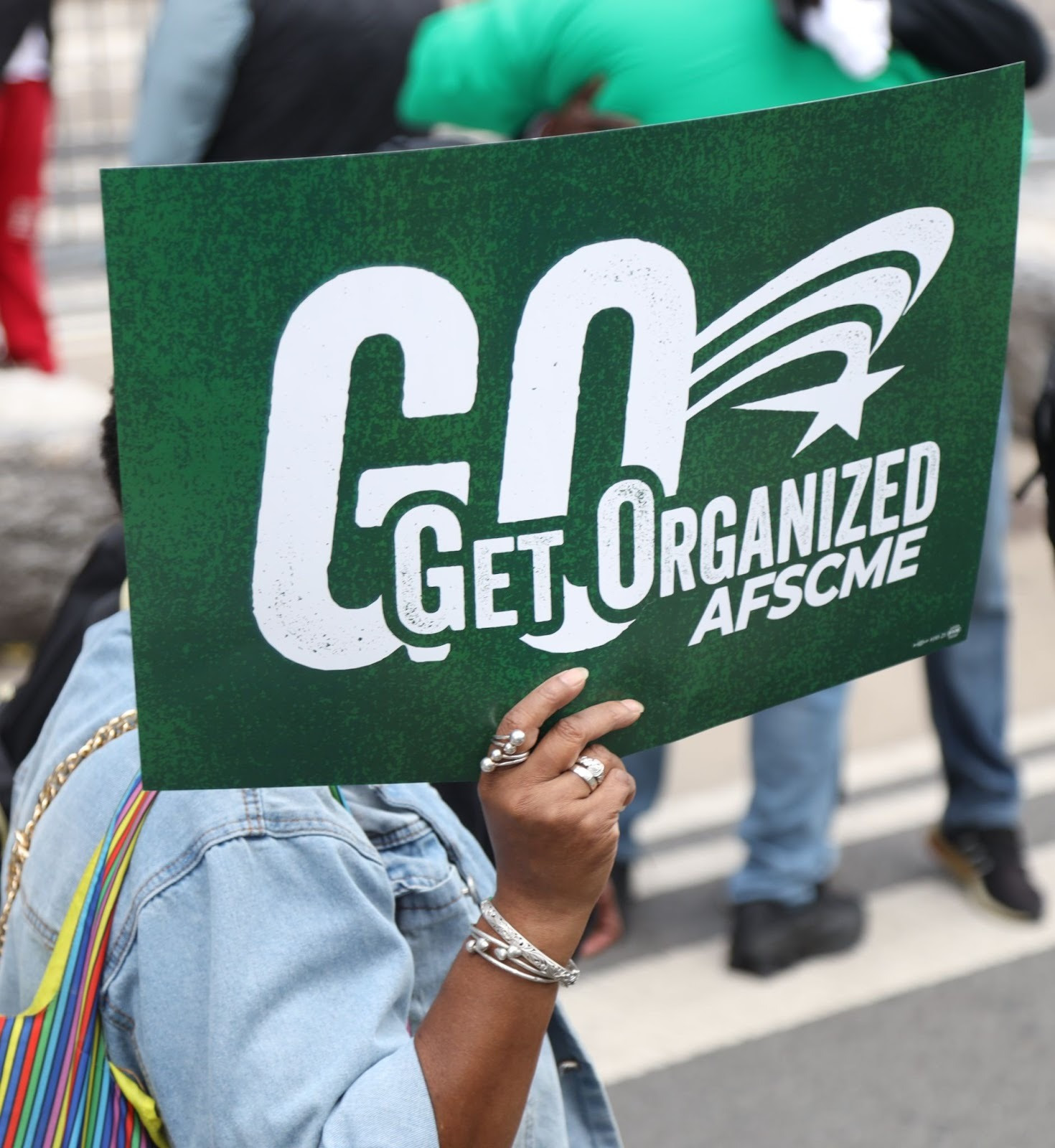 Person holding a sign with the logo for AFSCME’s Get Organized campaign.