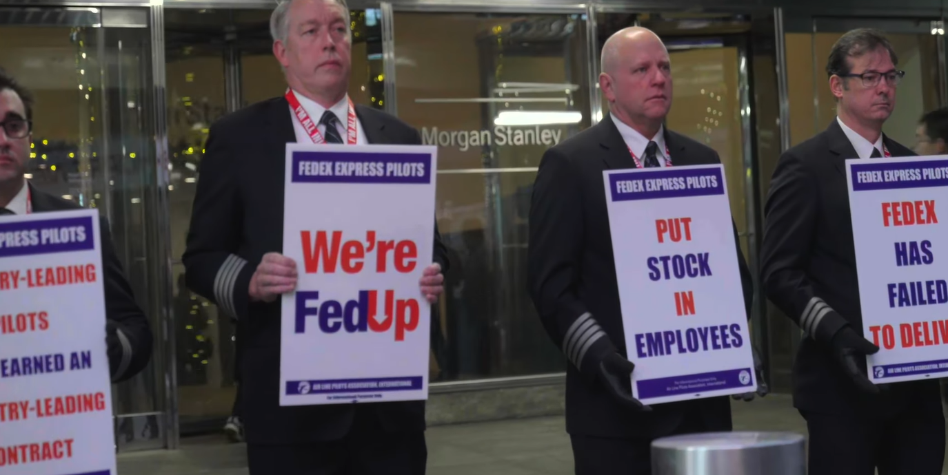 ALPA members holding signs that read “We’re FedUp,” “Put Stock in Employees” and “FedEx Has Failed to Deliver.”