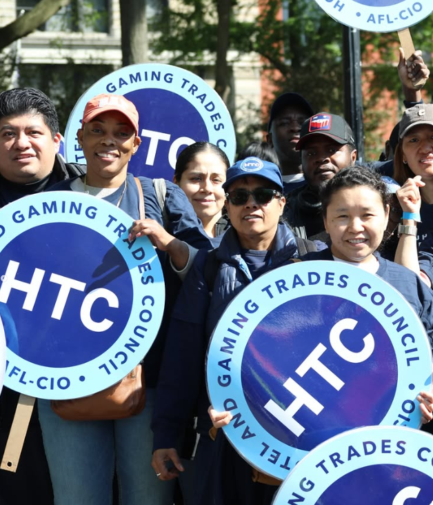Workers holding signs with the HTC logo.