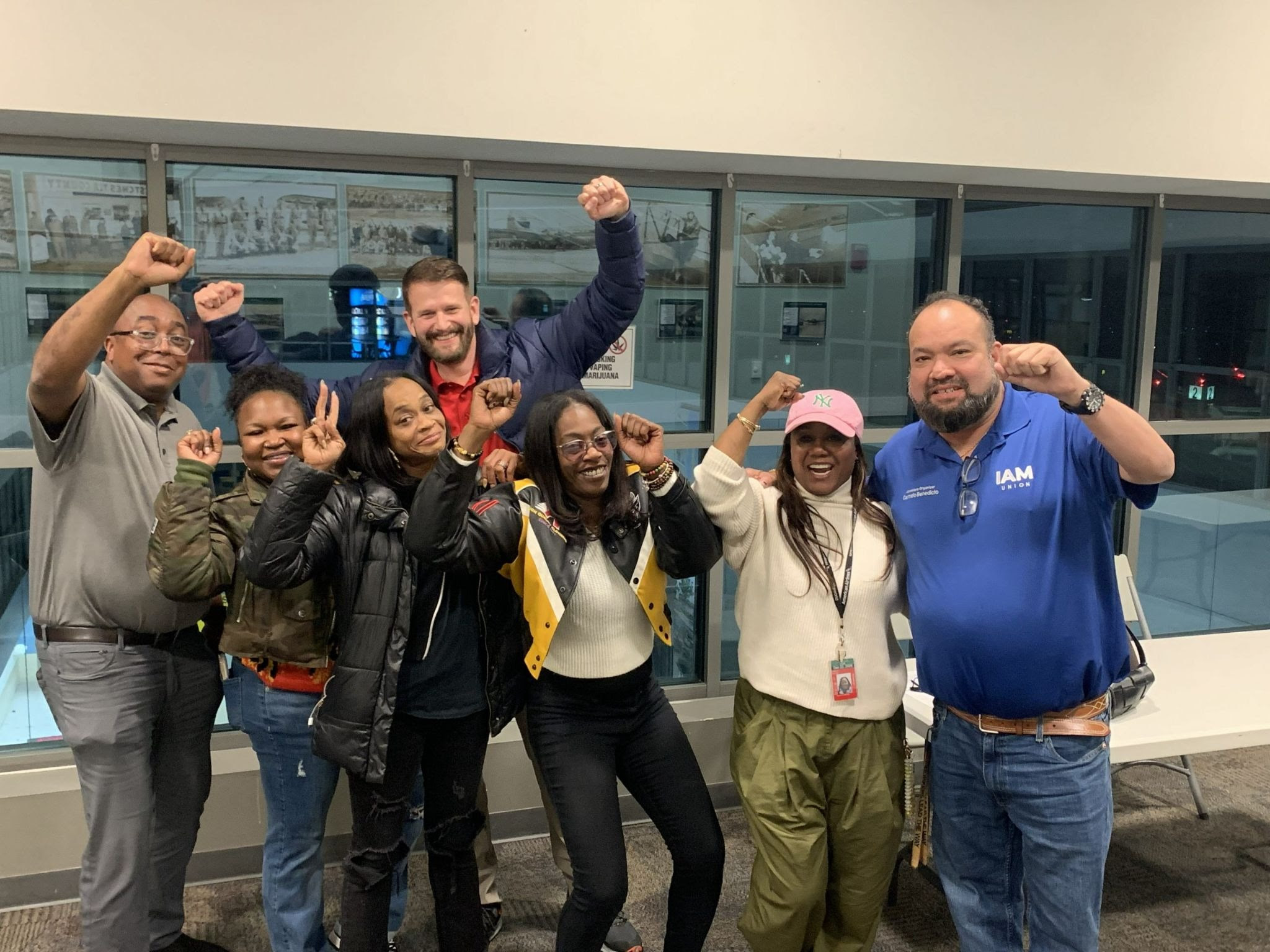 Workers pose for a group picture with fists raised in solidarity.