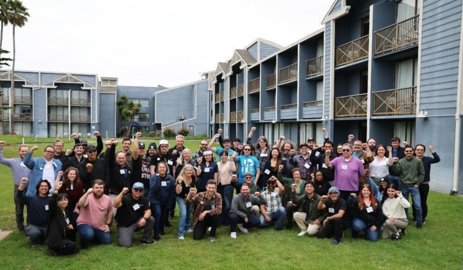 Tech workers posing for a group picture with fists raised in solidarity.