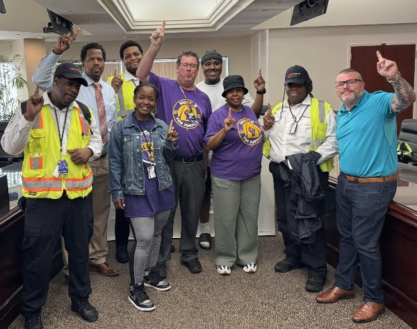 SEIU members pose for a group picture with their index fingers raised to signify Local 1.