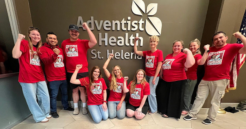 Adventist Health St. Helena nurses posing for a group picture with fists raised in solidarity.