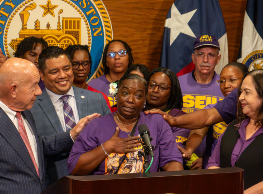Airport workers speak at a press conference.