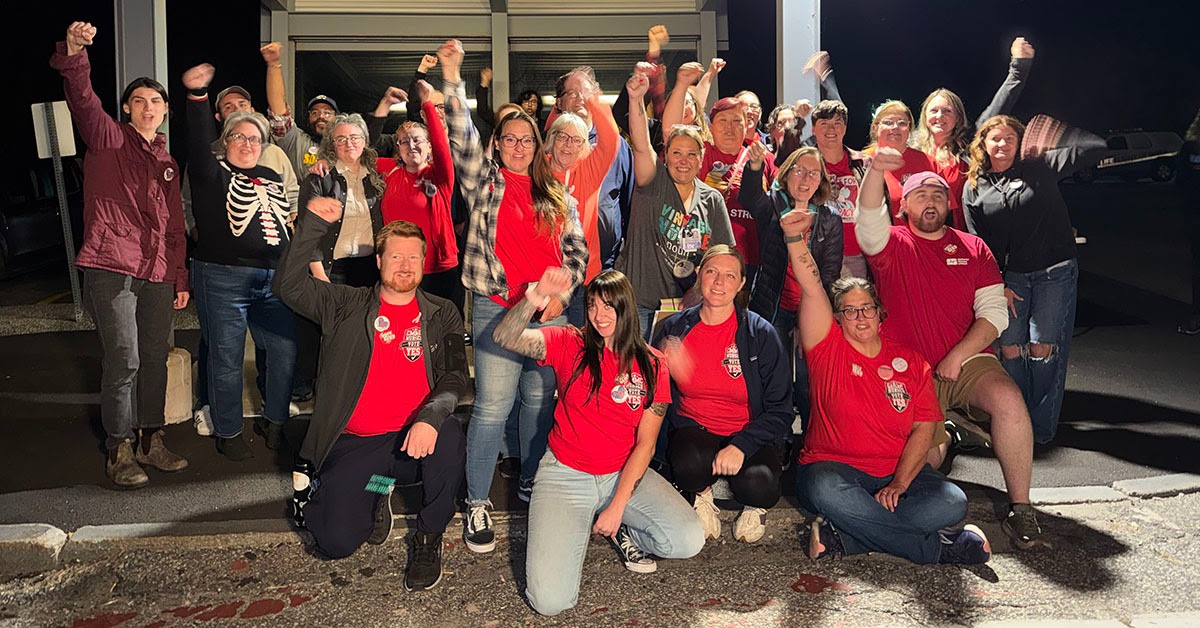 Nurses posing for a group picture with fists raised in solidarity.