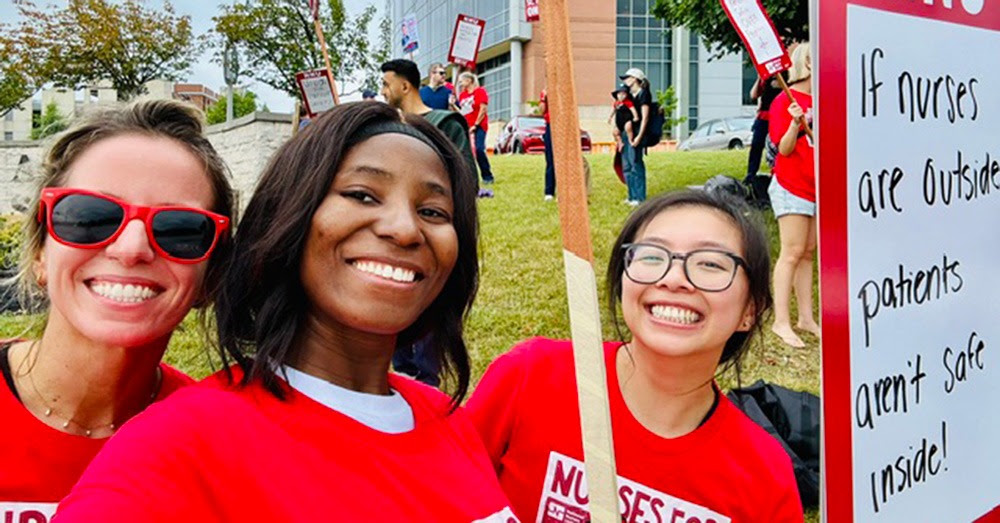 Nurses pose for a selfie at a rally.