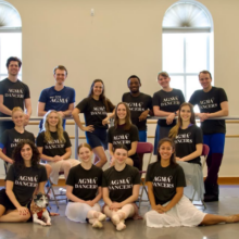 Dayton Ballet dancers posing for a group picture inside a ballet studio.