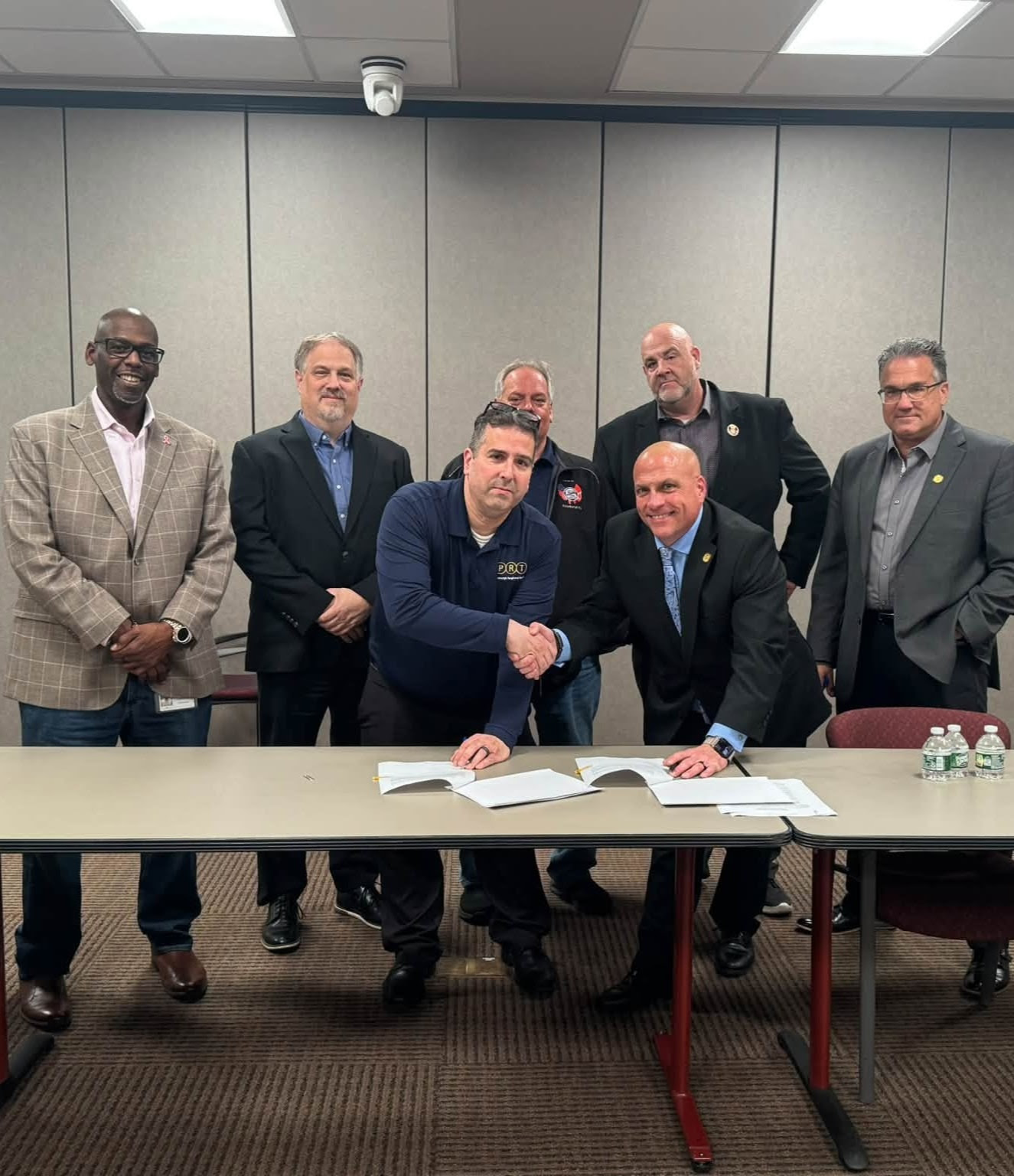 ATU Local 85 negotiating team shaking hands with a representative from PRT after finalizing the tentative agreement.