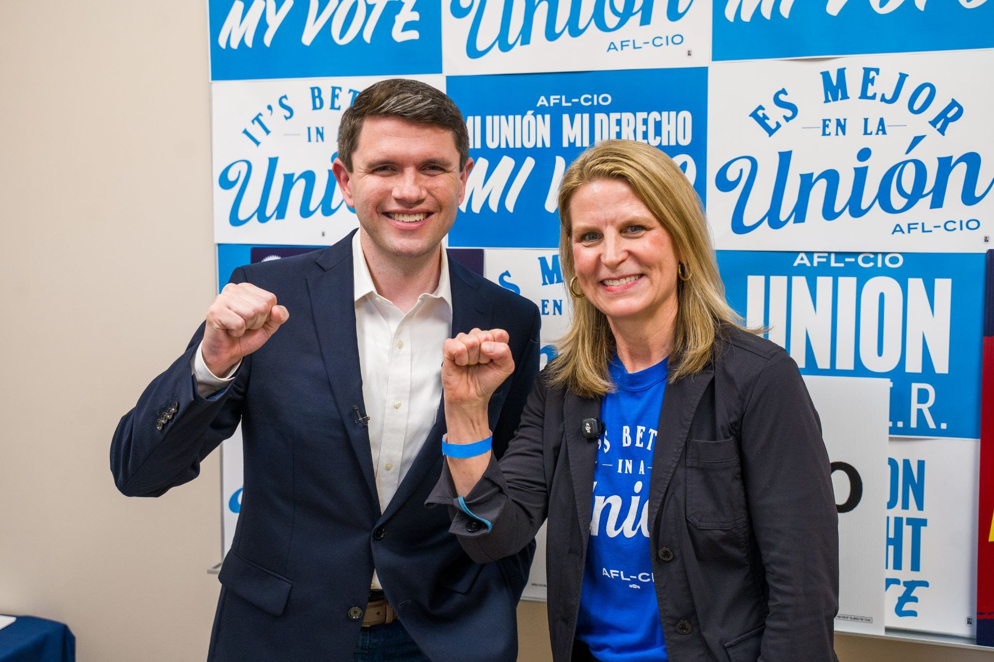 U.S. Senate candidate James Talarico and AFL-CIO President Liz Shuler posing for a picture with fists raised in solidarity.