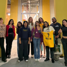 Workers pose for a group picture together.